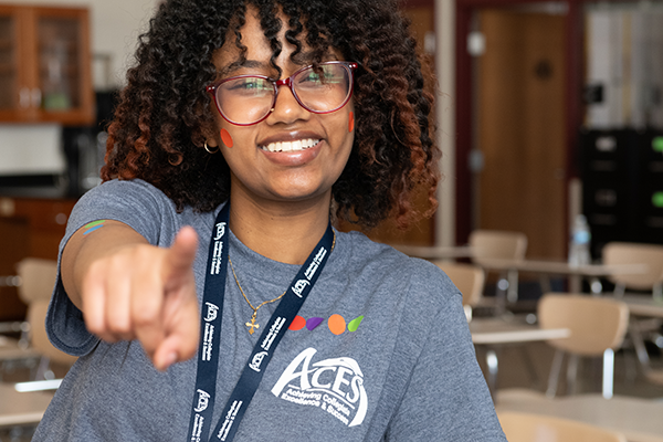 A Smiling ACES Student Pointing At The Camera