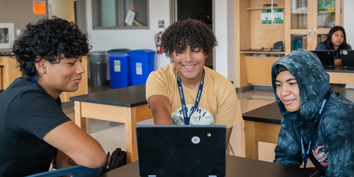 Three students at Wheaton High School looking at a computer